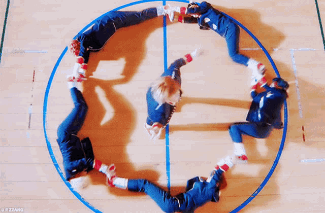 a group of people are laying in a circle on the floor