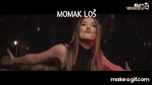 a woman is dancing in front of a sign that says ' momak los '
