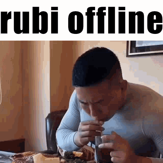 a man is sitting at a table eating a meal and drinking soda through a straw .