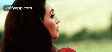 a woman with long hair is holding a red rose in her hand .