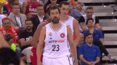 a basketball player with the number 23 on his jersey stands in front of a crowd