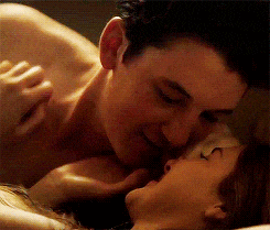 a man and a woman are kissing on a bed .
