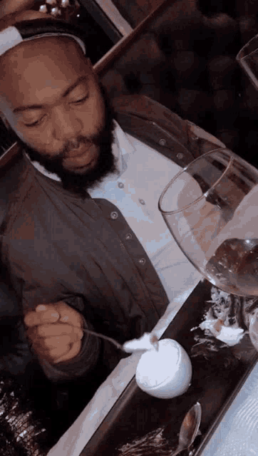a man with a beard is sitting at a table eating