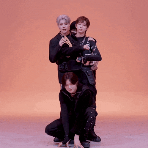 a group of young men are dancing with one wearing a black shirt that says ' a ' on it