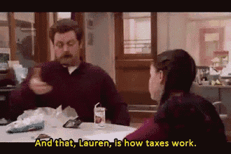 a man and a woman are sitting at a table talking about how taxes work
