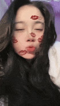 a woman with a lot of kisses on her face looks at the camera