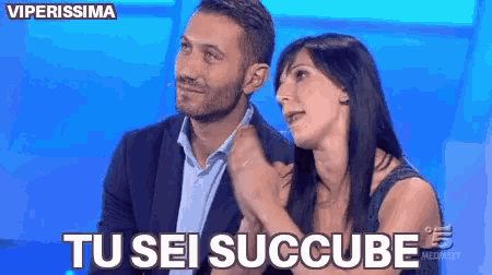 a man and a woman are sitting next to each other and the woman is saying tu sei succube