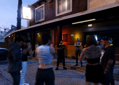 a group of people are standing outside of a building with a sign that says ' a & a ' on it
