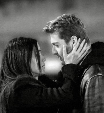 a black and white photo of a man and woman touching their faces