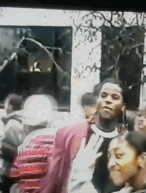 a man in a red jacket stands in front of a group of people