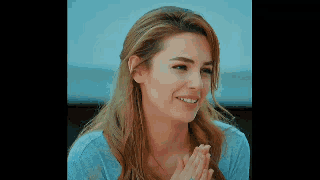 a close up of a woman 's face with her hands together