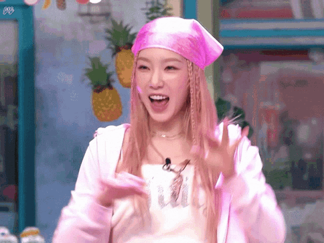 a woman wearing a pink head scarf and a pink jacket is smiling