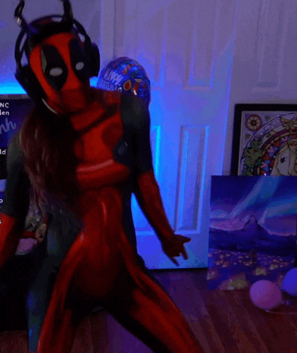 a woman in a deadpool costume is dancing in front of paintings