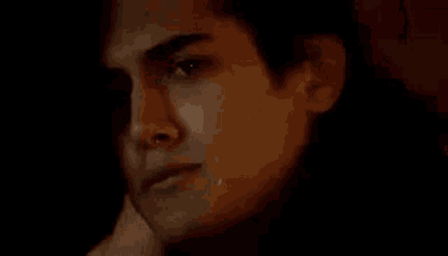 a close up of a man 's face with a tear running down his face .