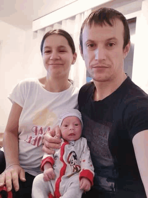 a man and a woman are posing for a picture with a newborn baby .