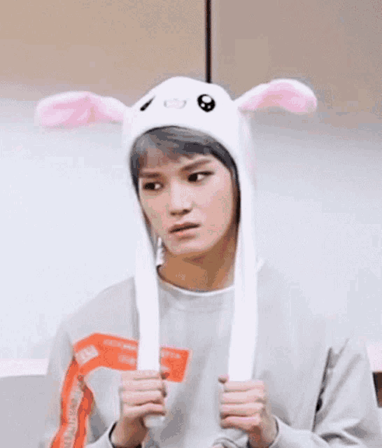 a young man is wearing a white bunny hat with moving ears .
