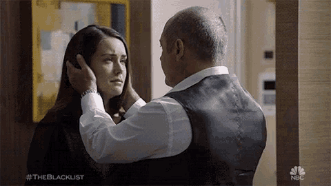 a man is touching a woman 's forehead with the hashtag #theblacklist in the corner