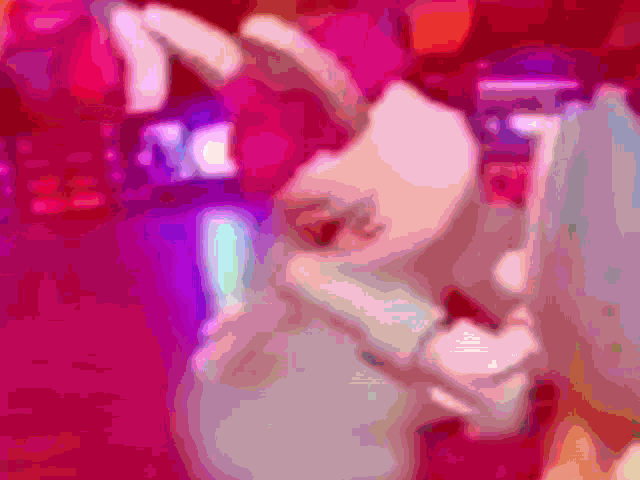 a blurred image of a person making a heart shape with their hands