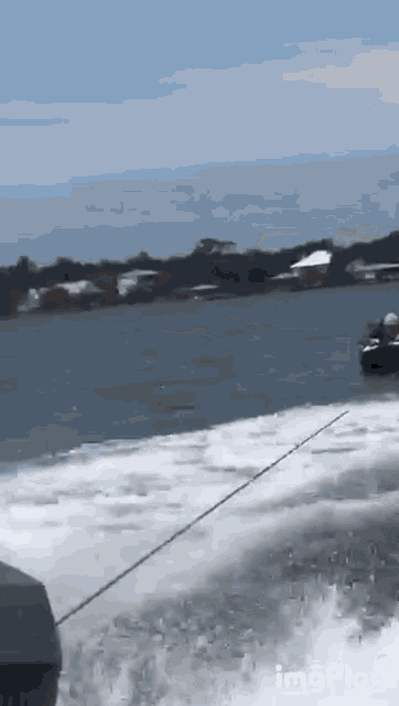 a boat is going through a body of water with houses in the background