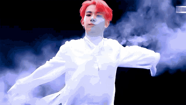 a man with red hair is wearing a white shirt and dancing