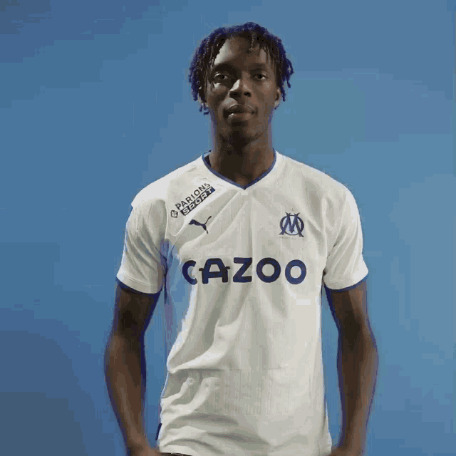 a man wearing a white shirt with cazoo on it