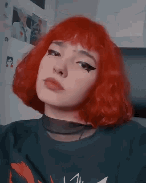 a close up of a woman 's face with red hair and a black choker .