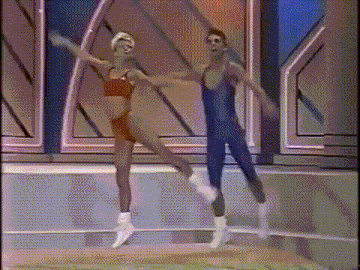 a man and a woman are dancing together on a stage in a dance studio .