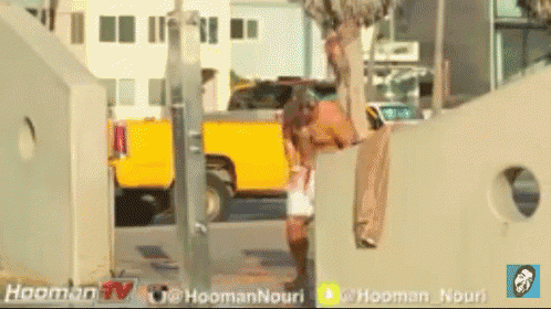 a yellow truck is parked on the side of the road next to a yellow sign that says ' hooman tv ' on it