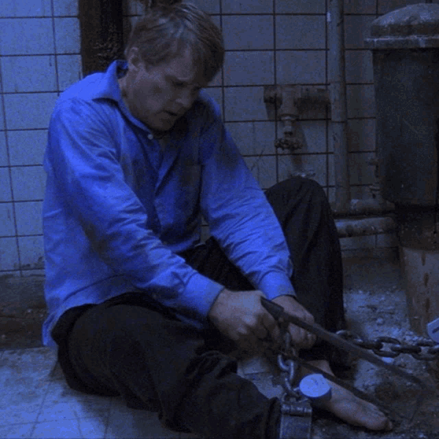 Sawing Through The Chain Cary Elwes GIF - Sawing Through The Chain Cary Elwes Lawrence Gordon GIFs