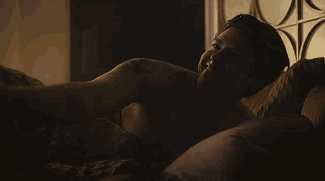 a man is laying on a bed with his head on a pillow