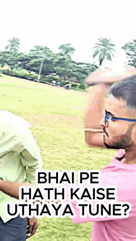 a man in a pink shirt is talking to another man in a field