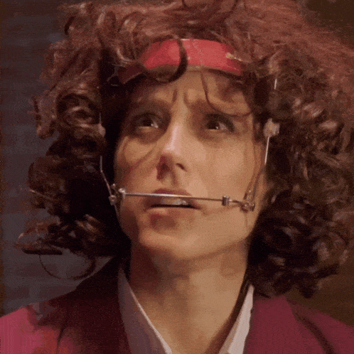 a woman with curly hair wearing a headband and braces