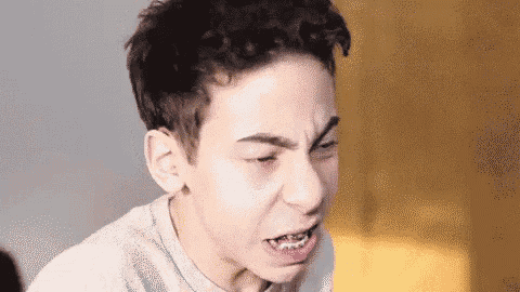 a young man with braces on his teeth is making a face .