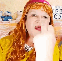a woman with red hair wearing a yellow shirt and a pink headband