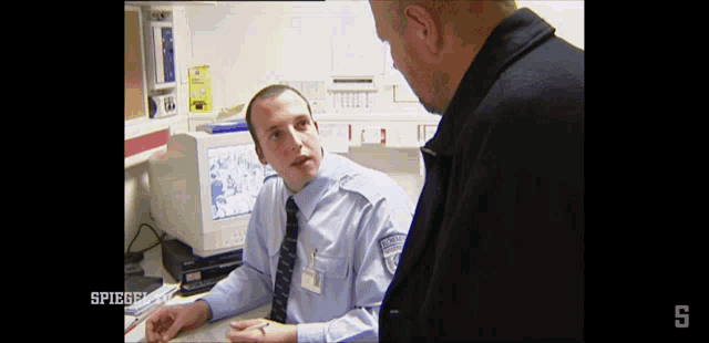 a man talking to another man with the word spiegel on the bottom right