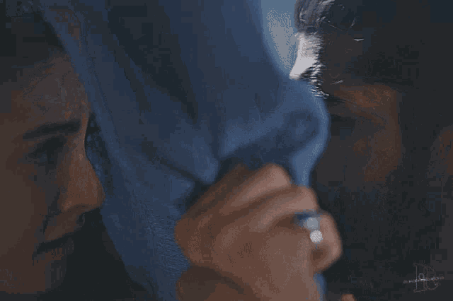 a close up of a man holding a woman 's arm with the letter b on the bottom
