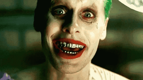a close up of a man in a joker costume with red lipstick and a tear in his eye .