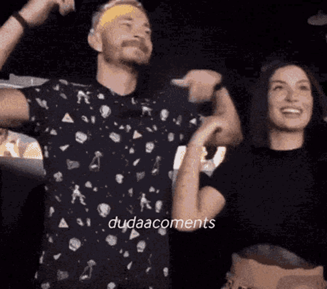 a man and a woman are dancing in a dark room with the words dudaacoments written on the bottom
