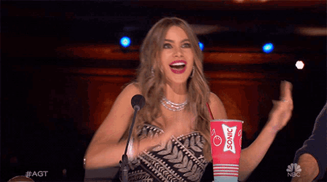 a woman is holding a cup that says sonic
