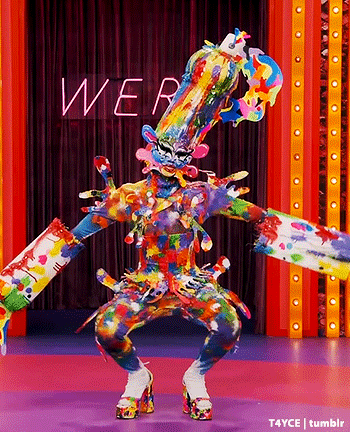 a person in a colorful costume is dancing on a stage in front of a sign that says wear .