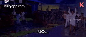 a group of people are standing in a room with smoke coming out of it and a man is saying no .