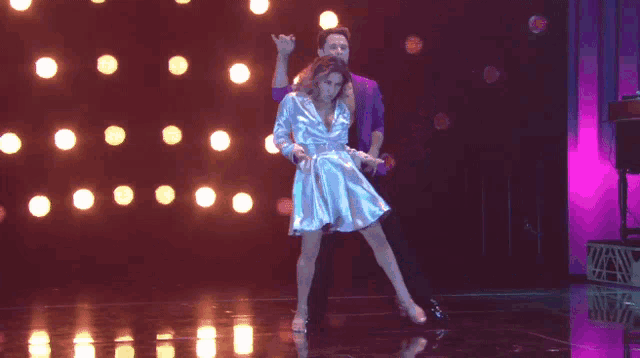 a man and a woman are dancing together on a stage
