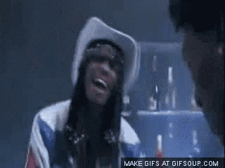 a woman wearing a cowboy hat is laughing in front of a man