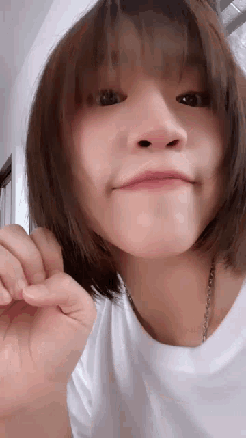 a close up of a woman making a face with her hand