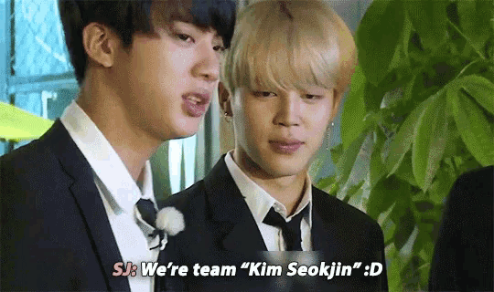 two men in suits are standing next to each other and one of them says we 're team " kim seokjin " ..