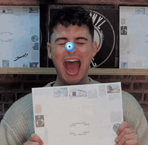 a man with a blue eye is holding a piece of paper with a stamp on it