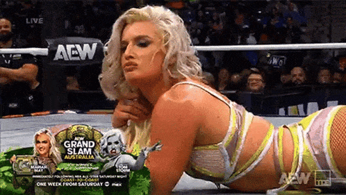 a woman is laying on the ground in a wrestling ring during a match .