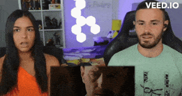 a man and a woman are sitting in front of a screen that says veed.io on the bottom