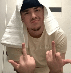 a man with a towel on his head giving the middle finger .