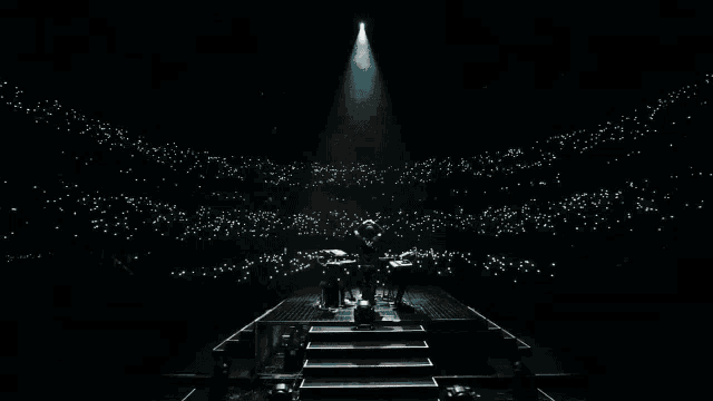 a man is standing on a stage in front of a crowd of people